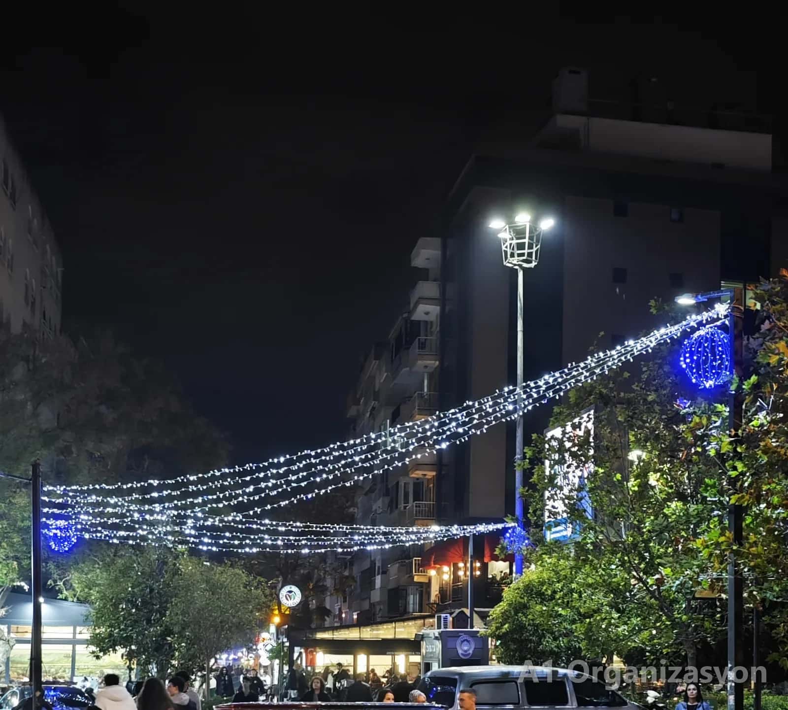 Cadde üstüne çapraz gerilmiş beyaz ve mavi LED ışık hatları - A1 Organizasyon